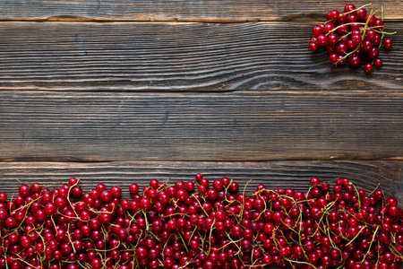 Fresh red ripe currants on a dark wooden background. Rustic style.