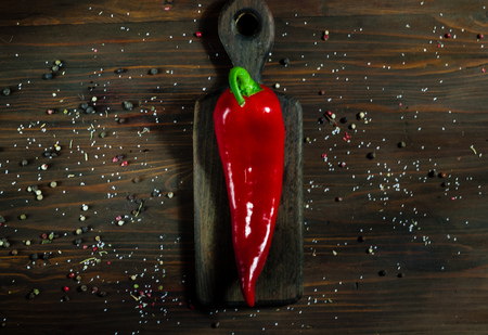 Red pepper on a dark wooden surface on a background of spices,  top viewの写真素材