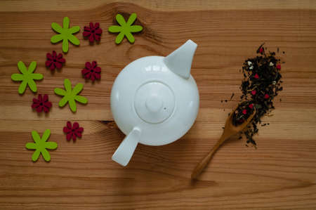 white ceramic teapot and decor of flowers on a wooden background, concept of festive composition, free space for textの写真素材