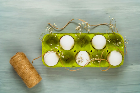 Decor for Easter holidays, eggs in a green box on a light wooden background, top view, blank space for textの写真素材