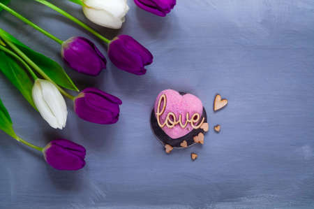 dessert and bouquet of ultraviolet tulips on a light background, top view, space for text,holiday conceptの写真素材
