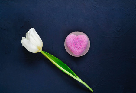 dessert  and a white tulip on a dark background, a festive decor concept, a top view, a space for textの写真素材