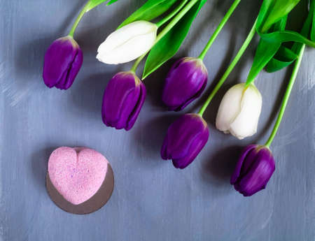 dessert and bouquet of ultraviolet tulips on a light background, top view, space for textの写真素材