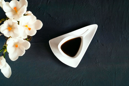 vintage white ceramic coffee cup on a dark concrete texture on a crocus background, top view, copy spaceの写真素材
