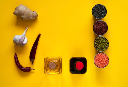 Asian food ingredients, spices and sauces on a yellow background. The concept of the most popular Chinese dishes in the world. Some types of Asian cuisine, top view, copy spaceの写真素材