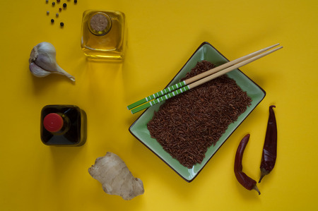 Asian food ingredients, spices and sauces on a yellow background. The concept of the most popular Chinese dishes in the world. Some types of Asian cuisine, top view, copy spaceの写真素材