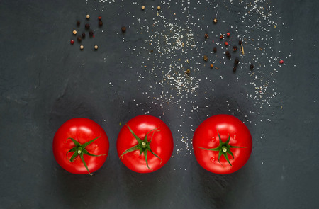 dark background with spices and fresh red tomatoes, close-up, top view, concept of cooking ketchup, copy space, minimalismの写真素材