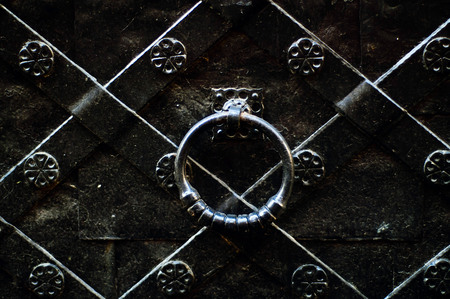 vintage door handle on a black iron door with forged products, copy space, concept of authentic objectsの写真素材