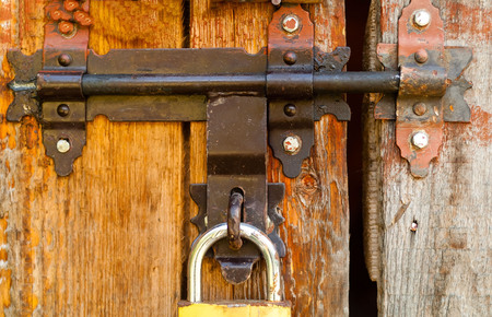 vintage lock on a rusty loop on a wooden background, copy space,closeup, concept of authentic...