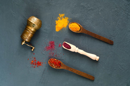 hand mill  and wooden spoons with spices on a dark background. The concept of vegetarian food,  healthy diet, choice of clean food, copy space, closeup.の写真素材