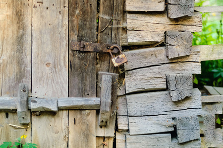 Authentic wooden door and a vintage lock on a rusty loop, copy space, concept of old objectsの写真素材