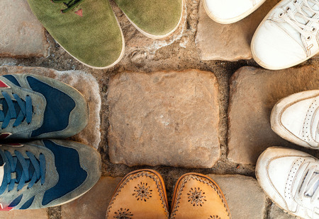 many feet in colorful sneakers stand in circle on stone,sport concept,  copy space, closeup,