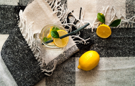 Citrus lemonade drink of soda water  in glass on plaid in Scandinavian style. Healthy and detox...