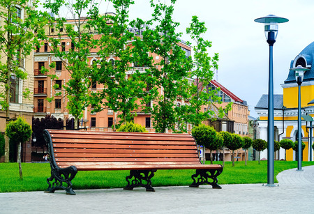 Wooden bench in the city park against the backdrop of urban buildings, concept of travel and recreation, Ukraine, Kiev, copy space, closeupの写真素材