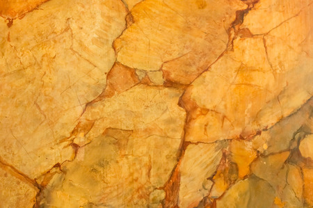 Marble background of bright yellow color, natural light, copy space, closeup.の写真素材