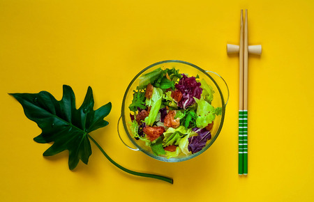 Hawaiian plate of salmon Poke with spicy. Homemade food. The concept of tasty and healthy meal. View from above. Copy space,yellow backgroundの写真素材