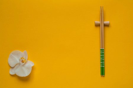 Creative yellow food background with orchid and chopsticks,clean food choice, close-up, copy space,flat lay.Trendy Bright Colors.の写真素材