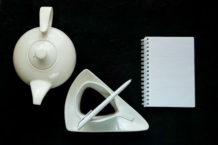 coffee break,teapot and vintage white ceramic cup with coffee on a dark background ,copy space, closeup,flat layの写真素材