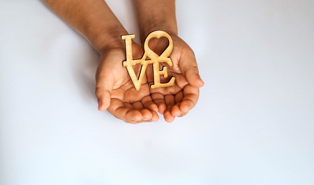 The word "LOVE" in  little hands of child,copy space, closeup, flat lay, isolatedの写真素材