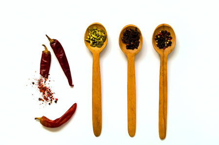 Wooden spoons with spices isolated on white background. The concept of vegetarian food,  healthy...