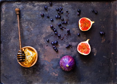 Fresh figs and honey in honeycombs. Vegetarian food, concept of natural products.