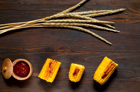 The Original Grilled Corn with spicy sauce on a wooden background. Top view, copy space, flat lay.