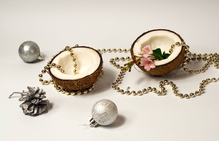 Creative layout of coconuts, concept of New Years holiday.Decorative Garland and silver balls on...