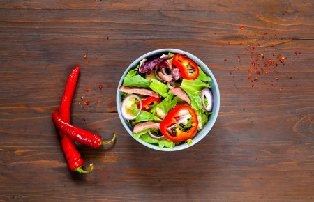 Salmon Poke Salad in blue bowl with beef on wooden background,organic food concept, detox food or vegetarian concept.Top view, copy space, flat lay.の写真素材
