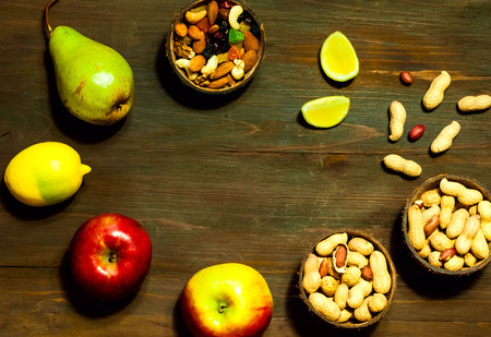 mix of nuts and fruitson on wooden background. Vegetarian food, detox products for proper nutrition, close up, copy space,flat layの写真素材