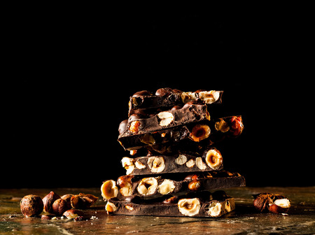 Chocolate pieces with almonds on dark background. Copy space, closeup