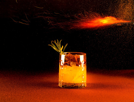 Tropical cocktail with fire on dark cinnamon background. Close up, copy space.の写真素材