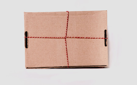 Cardboard Box with holiday string on white background. Close up. Copy space.の写真素材