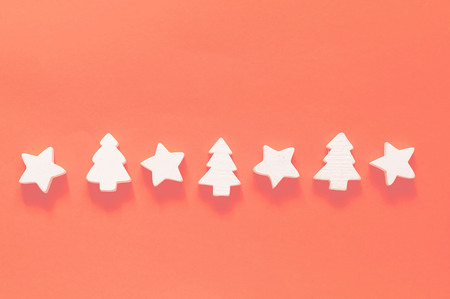 Christmas garland of wooden white decorations on the background of living coral. Color of the year 2019 concept. Holiday and celebration concept for postcard. Flat lay, Top view. Copy spaceの写真素材