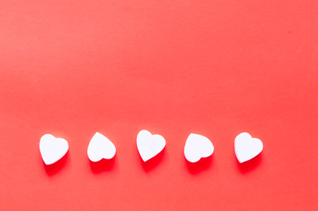 Valentines Day concept.Wooden white heart shape decorations on coral background. Holiday and...