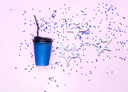 Coffee in disposable paper cups and white stars on pink pastel trendy background. Festive backdrop for projects. Flat lay, close up. Top view, copy space.の写真素材