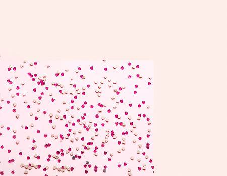 Festive pink  background with red spangles in the shape of heart. Concept Valentines Day. Closeup,...