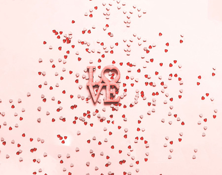 Festive pink background with spangles in the shape of heart. 
Closeup, copy space.の写真素材