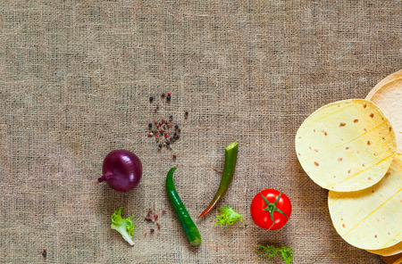 Traditional dish of Mexican cuisine. Corn tortilla tacos  and spices on  burlap texture. Closeup, copy space.の写真素材