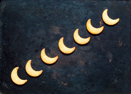 Cookie in moon shape on vintage rusty metal background. Ramadan festival background. Closeup, copy space.の写真素材