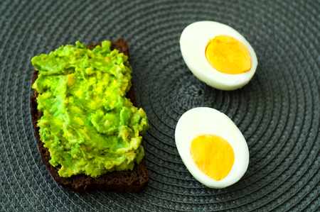 Healthy breakfast. Sandwich with avocado and egg. Closeup, copy space.の写真素材