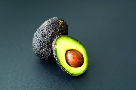 Avocado ready to eat on dark background. Healthy eating concept.