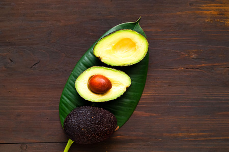 Avocado on tropical leaf. The concept of organic food. Close-up, copy space