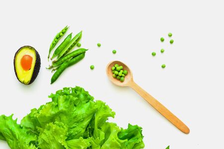 Wooden spoon and vegetables on isolated white background. The concept of organic products for...