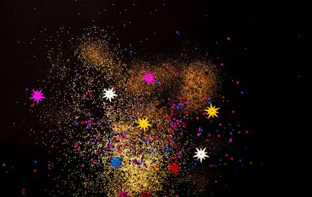Black background with golden and colored sparkles. Blurred  effect. Concept for festive background...