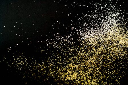 Black background with golden sparkles. Blurred  effect. Concept for festive background or for project.Close-up,copy spaceの写真素材