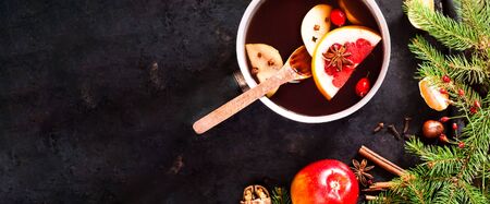 Christmas background. Hot mulled wine with ingredients in authentic ladle on on vintage rusty metal background. The concept of celebration and cooking warming drinks. Top view, close up, copy spaceの写真素材