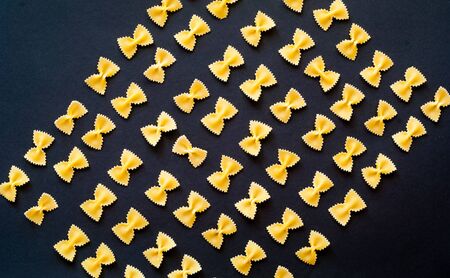 Pattern from Italian pasta farfalle. Food concept. Close-up, copy spaceの写真素材