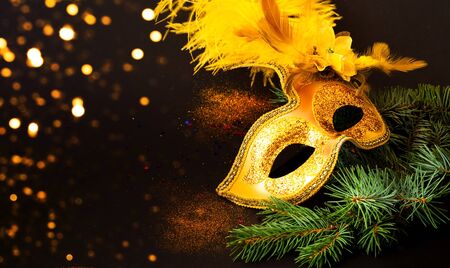 Masquerade mask on black background with confetti. New Years decor. Blurred effect. Close-up, copy spaceの写真素材