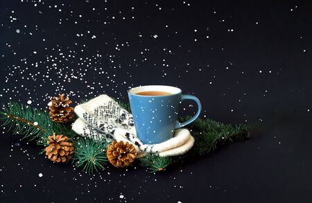 Cup of  tea on knitted mittens. Christmas background. Hyugge style. Close-up, copy spaceの写真素材
