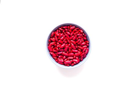 Beans in blue bowl on white isolated background. Mexican food ingredient. Close-up, copy spaceの写真素材